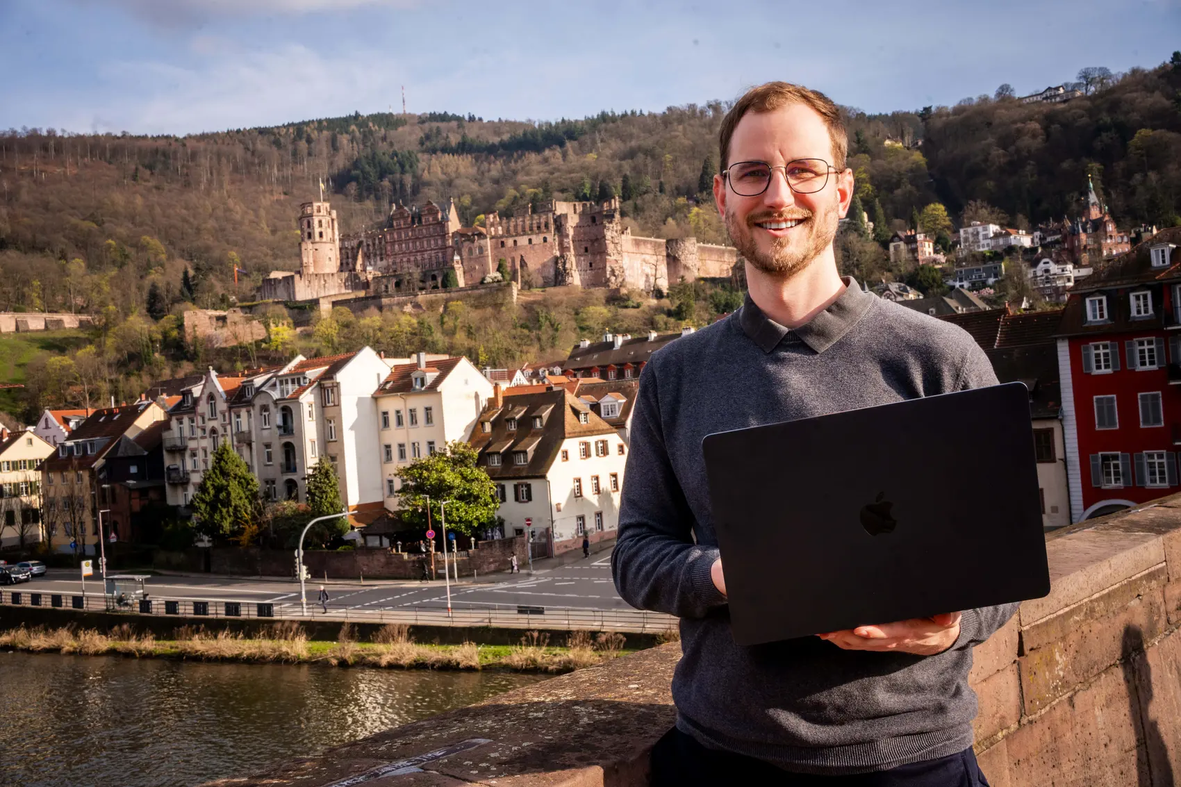 Joshua Stark mit MacBook vor dem Heidelberger Schloss