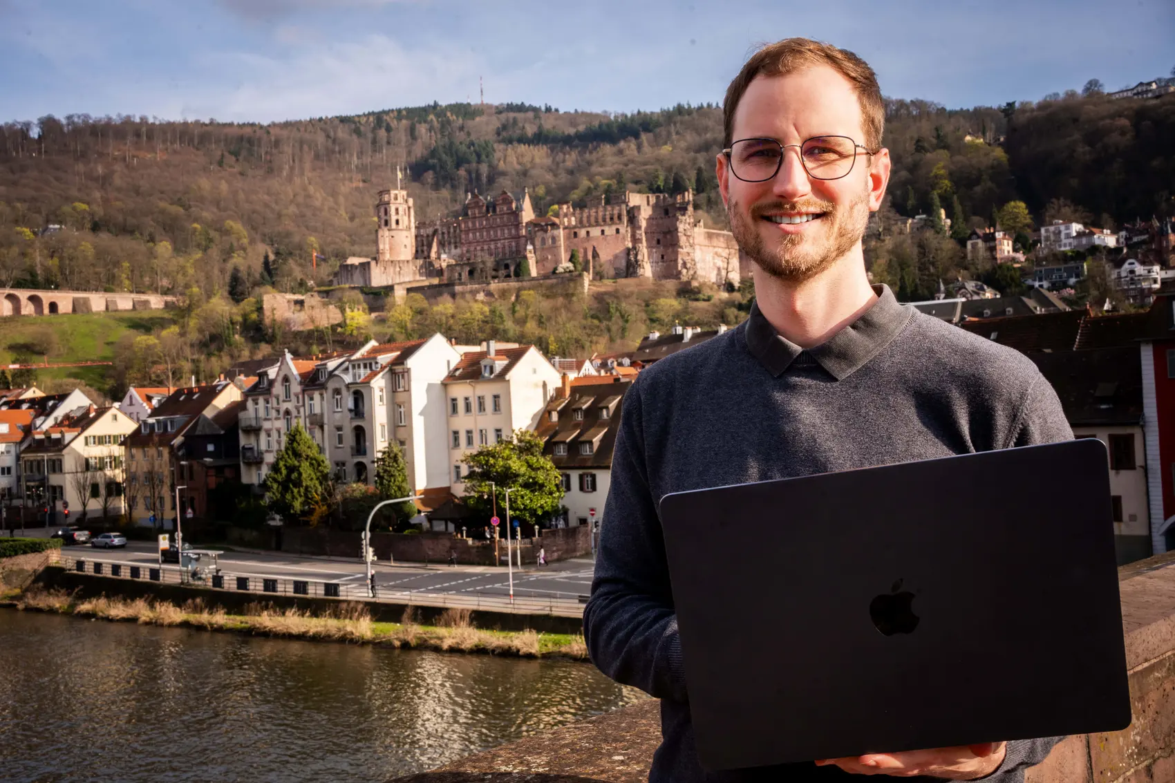 Joshua Stark mit MacBook vor dem Heidelberger Schloss