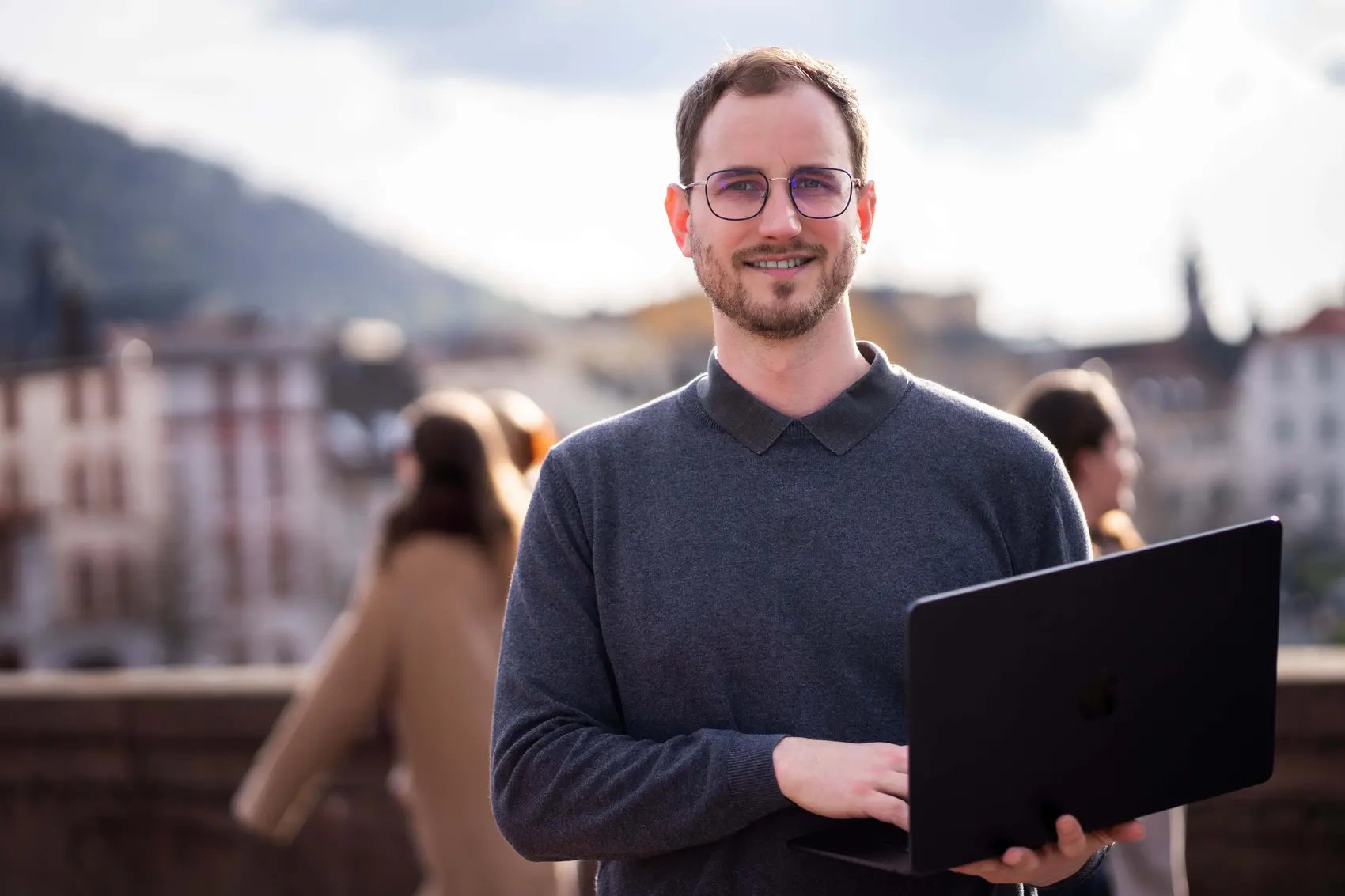 Joshua Stark mit MacBook über den Dächern von Heidelberg